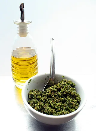 stirring olive oil into cilantro pesto mixture
