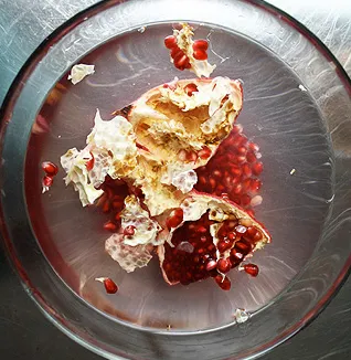 de-seeding pomegranates in a bowl of water